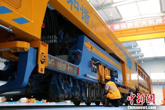 圖為工人正在清理大型養(yǎng)路機(jī)械?！堖h(yuǎn) 攝